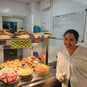 Team member standing next to breakfast food